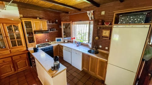 Rustic wooden kitchen at Casa Rural Villa del Jerte with beamed ceiling, gas stove, and countryside charm