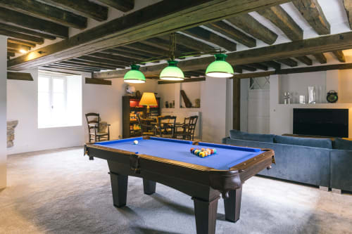 Salle de jeux au Prieuré Du Preux avec billard, luminaires suspendus verts, poutres apparentes et salon de détente