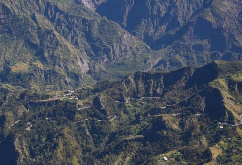 Vue aérienne de l'hôtel Au pied des Sources niché dans la vallée montagnarde de Cilaos, entouré de forêts