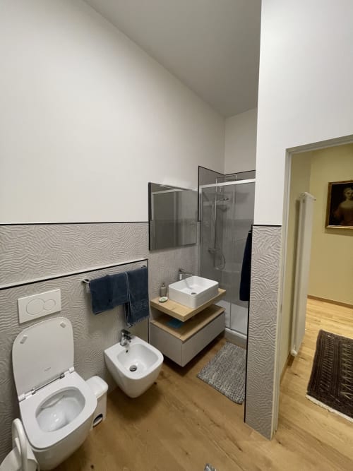 Bagno moderno dell'appartamento Saint Michel a Gorizia con wc, bidet, lavabo sospeso e doccia walk-in