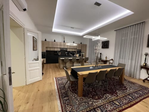 Zona pranzo moderna con cucina dell'hotel Saint Michel a Gorizia, Italia, con tavolo in legno e arredamento contemporaneo