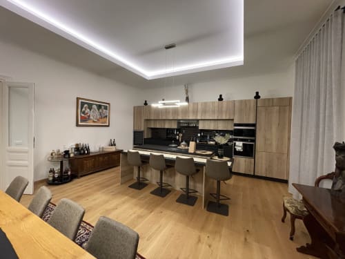 Cucina moderna dell'appartamento a Saint Michel Gorizia con mobili in legno, isola cucina e plafoniere contemporanee