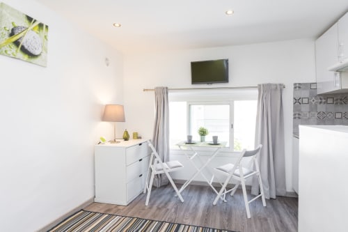 Modern studio apartment at Azur Studios Cannes with dining area, kitchenette, TV, and city view from window