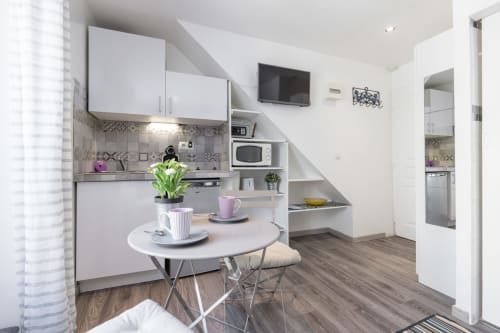 Modern Superior Studio at Azur Studios Cannes with equipped kitchenette, dining area, TV, and staircase storage in Cannes