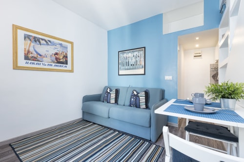 Blue and white Superior Studio at Azur Studios Cannes with sofa, dining area, and kitchenette
