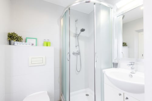 Modern bathroom in Superior Studio at Azur Studios Cannes with glass shower enclosure, white sink, and clean minimalist