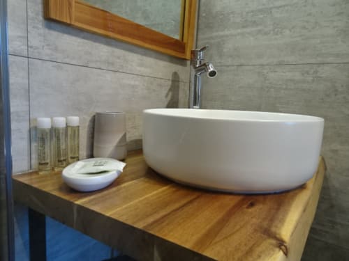 Une salle de bain privative avec des produits d'accueil : gel douche, shampoing, savon.