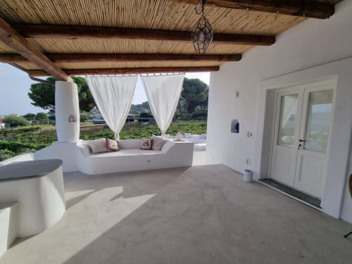 Miravilla Salina terrace with built-in seating, white curtains, wooden pergola overlooking vineyards in Santa Marina Salina