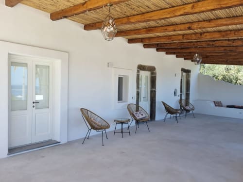 Miravilla Salina terrace with wicker chairs, wooden beams, and white walls overlooking Santa Marina Salina