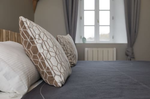 Slaapkamer in Moulin Renaudiots in Autun met decoratieve kussens en raam met uitzicht op de tuin