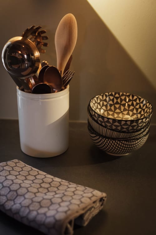Gestyleerde keukengereedschappen en decoratieve schalen in het appartement Moulin Renaudiots in Autun, met houten lepel en georganiseerde opbergruimte