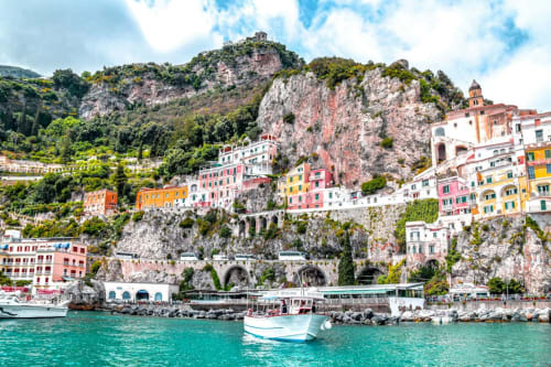 Colorful cliffside buildings of Atrani near Casa Castagna in Salerno, Italy, with turquoise waters below