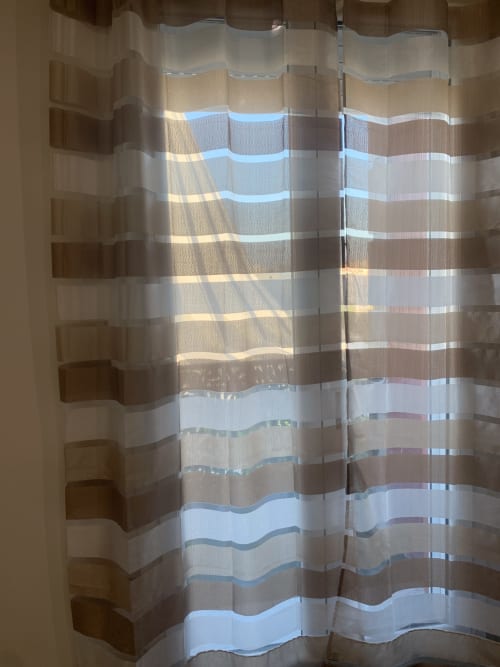 Striped sheer curtains with sunlight casting shadows in a double deluxe room at Maryam 23 boutique hotel in Siracusa