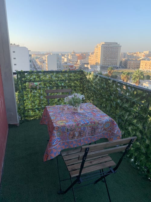 Rooftop balcony at Maryam 23 in Siracusa with city views, furnished table and greenery