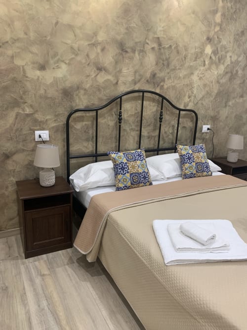 Double Deluxe room at Maryam 23 bed and breakfast in Siracusa with black iron headboard and decorative pillows
