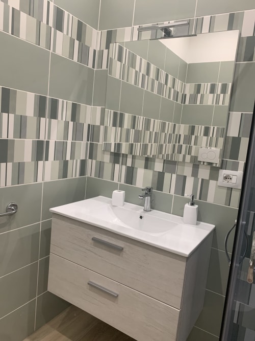 Modern bathroom sink and vanity at Maryam 23 B&B in Siracusa with geometric tile wall design