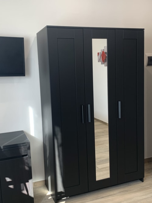 Black modern wardrobe with mirror in Maryam 23 Deluxe room, Siracusa
