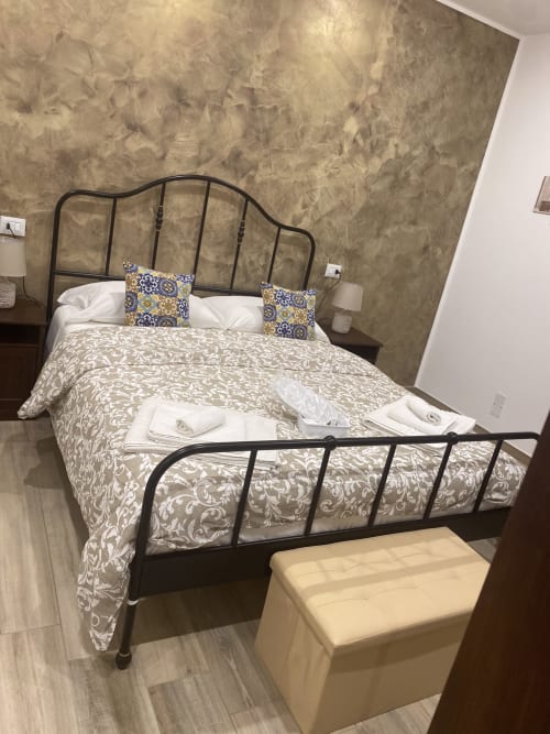 Elegant bedroom at Maryam 23 B&B in Siracusa with ornate metal bed frame and patterned bedding