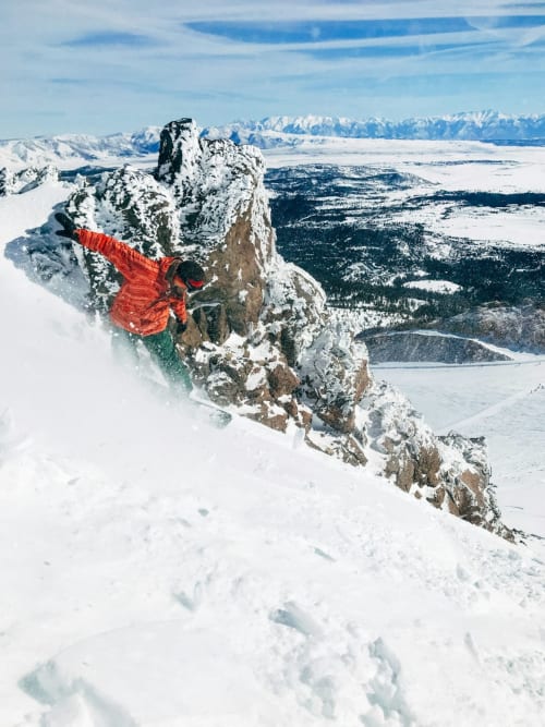 Skifahrer in roter Jacke auf verschneitem Gipfel nahe Hotel Le Clou, Arvier, Italienische Alpen