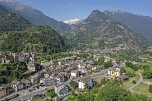 Luftaufnahme des Hotels Le Clou im Tal von Arvier mit schneebedeckten Bergen, alpinem Dorf und grünen Wäldern