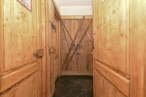 Corridoio rustico con porte di scuderia e cancello a croce presso l'Hotel Le Clou, Arvier