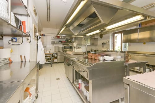 Cucina commerciale professionale dell'Hotel Le Clou ad Arvier con attrezzature in acciaio inossidabile e postazioni di lavoro