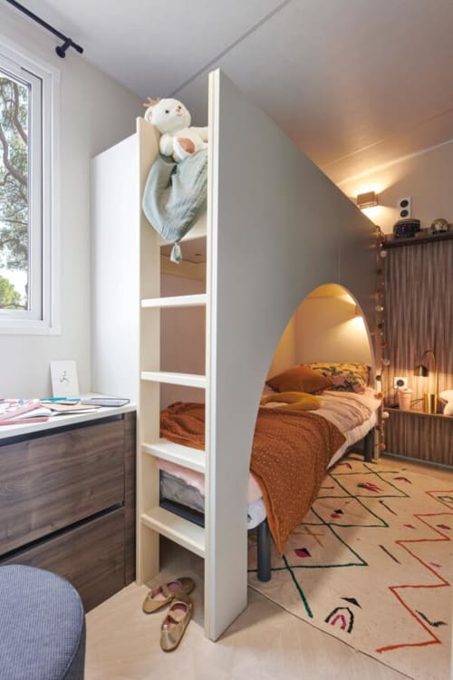 Chambre d'enfant moderne au Maquis Plage avec lit superposé, espace de travail et sol aux motifs ludiques