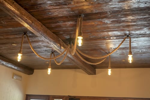 Soffitto con travi di legno rustico e luci a sospensione avvolte in corda all'Hotel Le Clou, Arvier