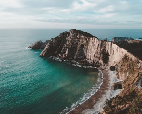 Dramatic coastal cliffs with turquoise waters near Ribadesella, Spain - Esto si es vida hotel location