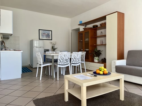 Appartamento open-plan a Tirreno con tavolo da pranzo, zona living, cucina e arredi moderni a Tirrenia