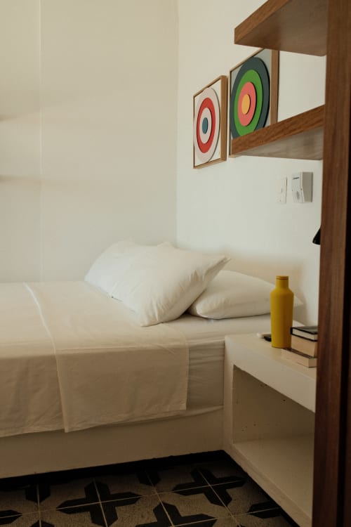 Habitación del boutique lodge Seaflower con almohadas blancas, arte mural colorido y marco de madera en San Andrés