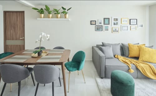 Sala de estar y comedor de apartamento moderno en CDMX con sofá gris, acentos turquesa, mesa de madera y plantas en macetas
