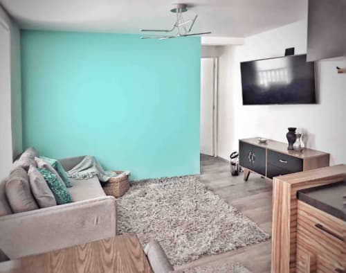 Moderno apartamento en México City de Pares Homes con pared turquesa, sofá gris y área de entretenimiento