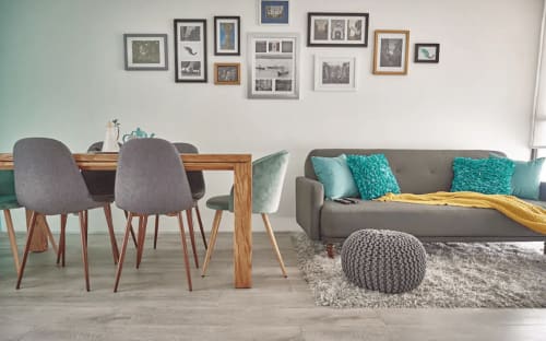 Moderna sala de estar con comedor, sofá gris, toques turquesas y galería de arte en Pares Homes, Ciudad de México