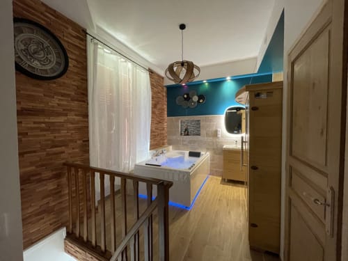 Salle de bain spa luxueuse avec jacuzzi, baignoire éclairée bleu, finitions bois, équipements modernes, Chartrettes BnB