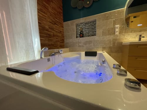 Luxueux bain à remous avec éclairage bleu dans la salle de bain moderne de la Suite d'amour et détente, Chartrettes BnB