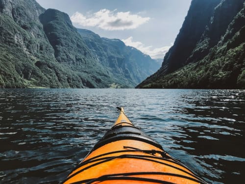 Kayak naviguant dans un canyon de fjord alpin aux falaises abruptes en Savoie