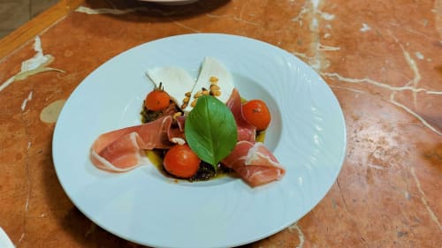 Élégante mise en assiette avec jambon de Parme, tomates cerises et basilic à La Bergerie Du Moulin, Taradeau