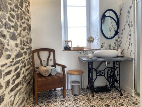 Salle de bain charmante à L'Ermitage B&B à Saint-Vaast-la-Hougue avec murs en pierre, vasque et décoration vintage