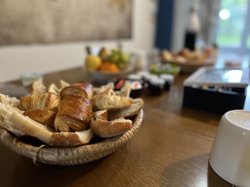 Viennoiseries et croissants dans un panier en osier à L'Ermitage, gîte à Saint-Vaast-la-Hougue