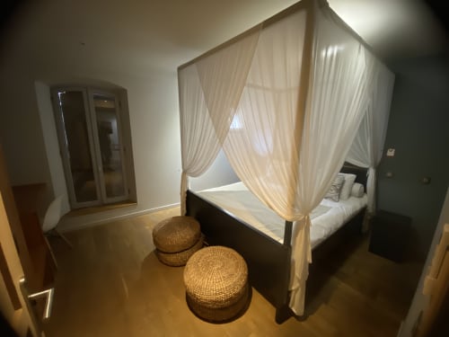Lit à baldaquin luxueux avec rideaux voilage dans la chambre moderne de AJOUCADOU BnB à Lourmarin, France