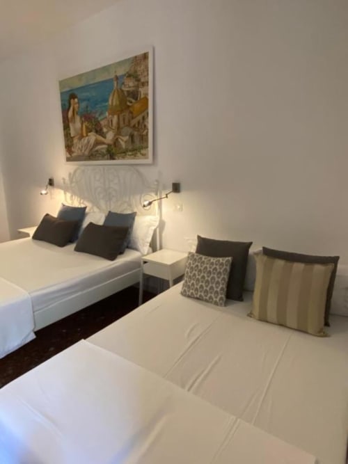 Deluxe double room at Casa Castagna in Salerno with two beds, ocean views, and Italian artwork on wall
