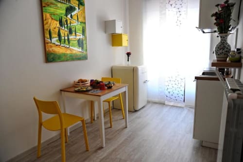 Deluxe Studio Apartment kitchen and dining area at Casa Castagna in Salerno with yellow chair and modern kitchenette