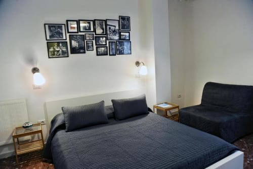 Economy Double Room at Casa Castagna B&B in Salerno with dark blue bedding, black framed photo gallery wall, and modern