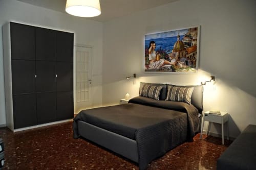 Modern bedroom at Casa Castagna with black bed, wardrobe, Mediterranean artwork, and coastal view in Salerno