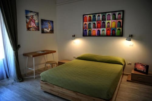 Bright Deluxe Studio Apartment at Casa Castagna in Salerno with green bed, desk, colorful artwork, and wood flooring
