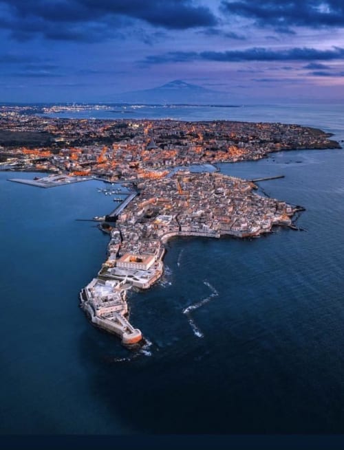 Aerial view of Siracusa's historic peninsula with Mediterranean Sea at dusk, showing Maryam 23 B&B location