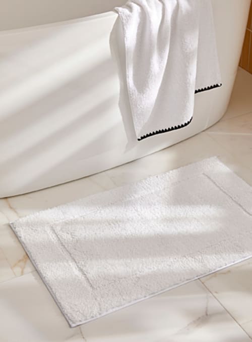 Serviettes blanches et tapis de bain dans la salle de bain moderne de Locations Loc'Maria, Belle Île en Mer