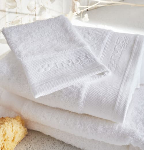 Serviettes de luxe blanches avec bordure décorative à Locations Loc'Maria, location de vacances à Belle Île en Mer