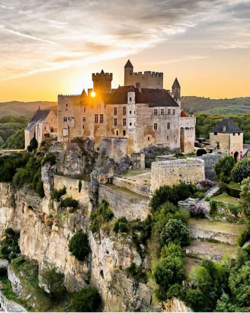 Le château de Neuschwanstein sur une falaise rocheuse au coucher du soleil, près de Thénon, France